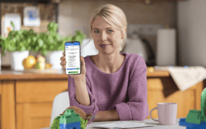 Kobieta trzyma w ręku smartfon i pokazuje stronę platformy e-kruk.pl